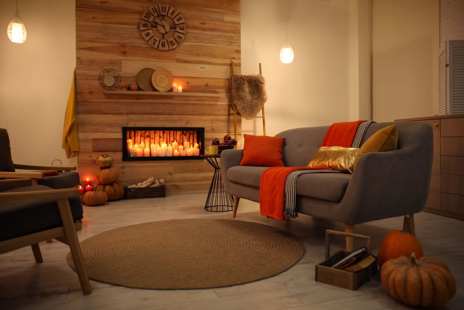 living room with a fireplace, gray couch, round carpet, dim lightning