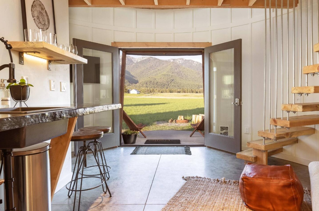 glass entry doors opened and looking at the view of the outdoors green land