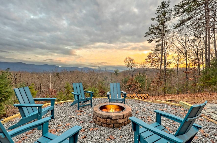 fire pit surrounded by blue chairs with a beautiful view