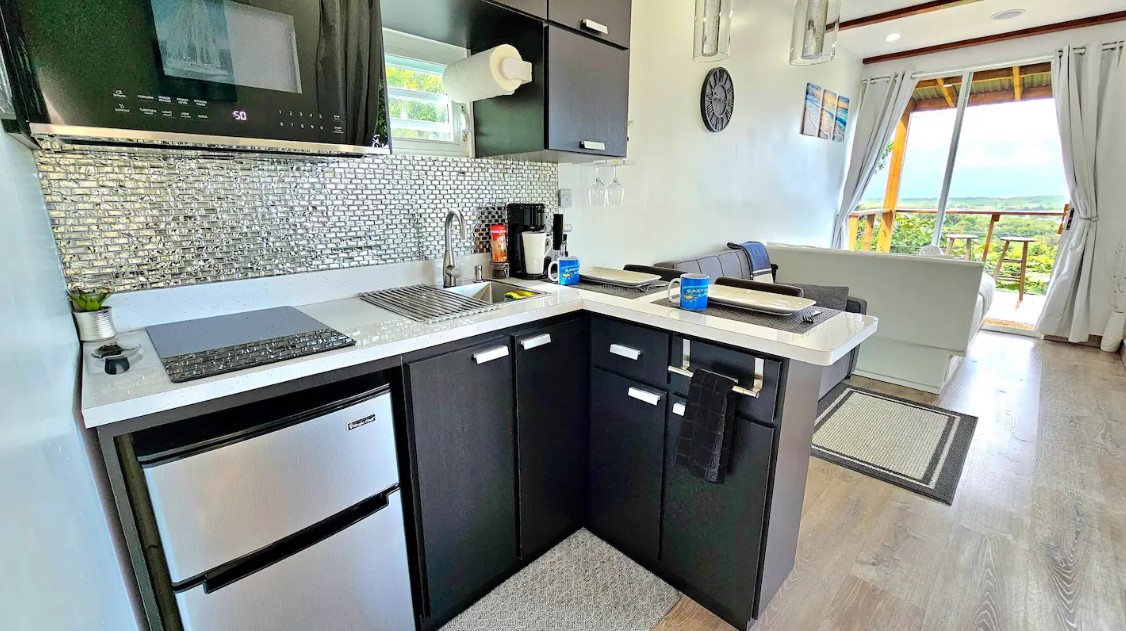 kitchen with black cabinets and white countertop, tiny window