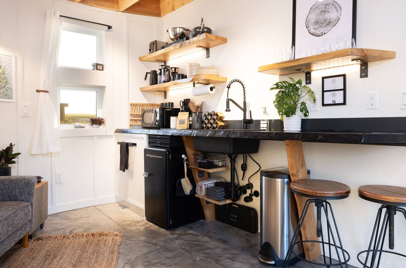 kitchenette with a black countertop and brown shelves