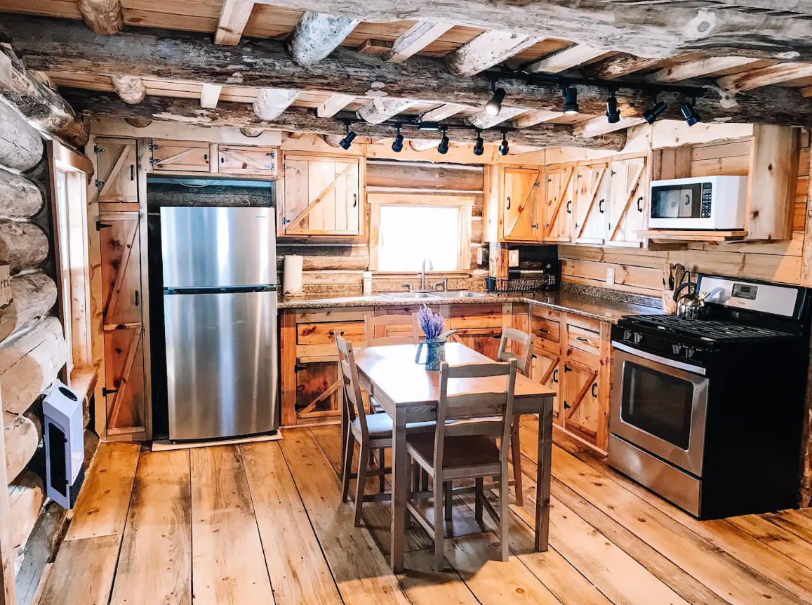 kitchen with brown cabinets, brown dining table accompanied by brown chairs, an oven, a microwave and a fridge