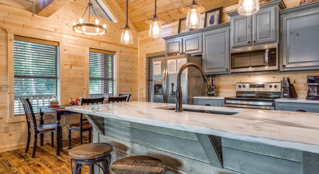 kitchen with gray cabinets and a brown dining table in the back