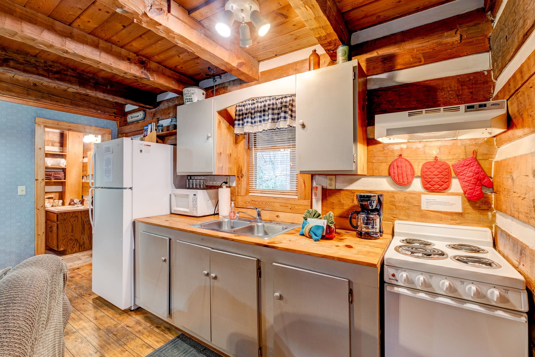 kitchen with white cabinets, a tiny window and wooden countertop