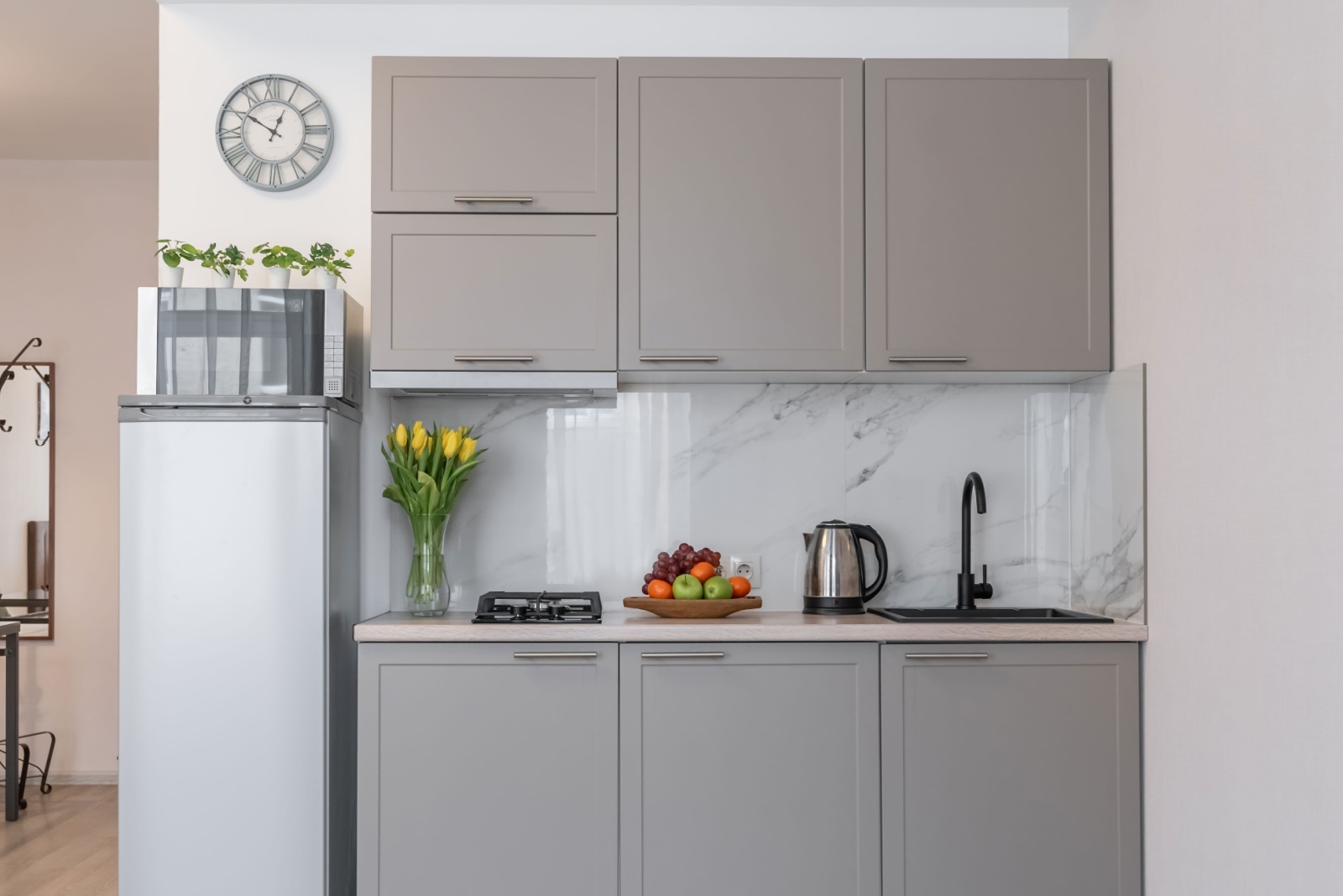 light gray cabinets of the kitchen and marble tiles