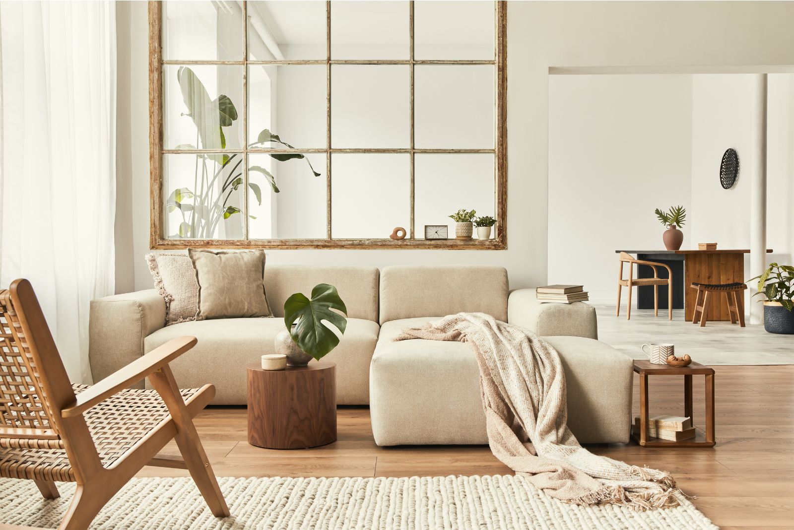 Living room with a window into a kitchen, white couch and a wooden coffee table