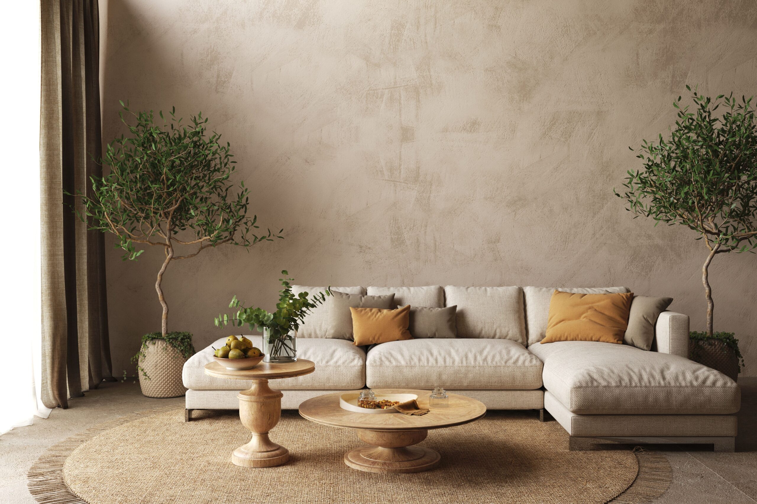 living room with two plants on the sides of the room, light beige l-shaped couch, round brown table