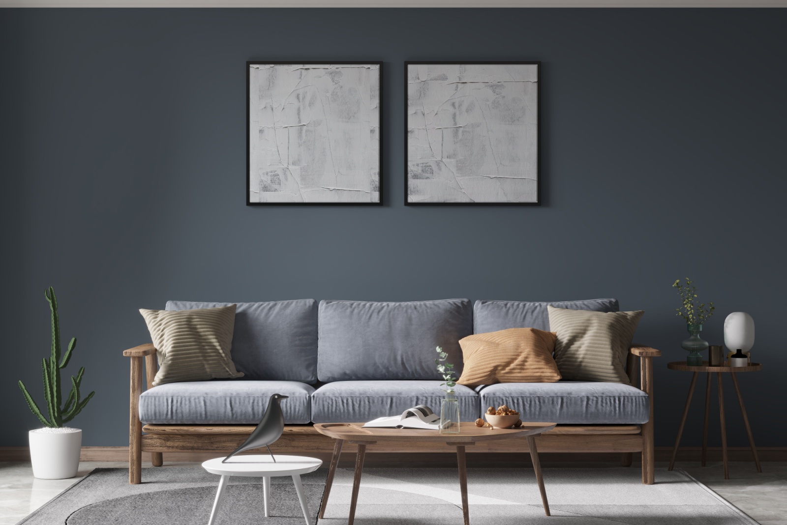 living room with two art pieces above the blue-gray couch