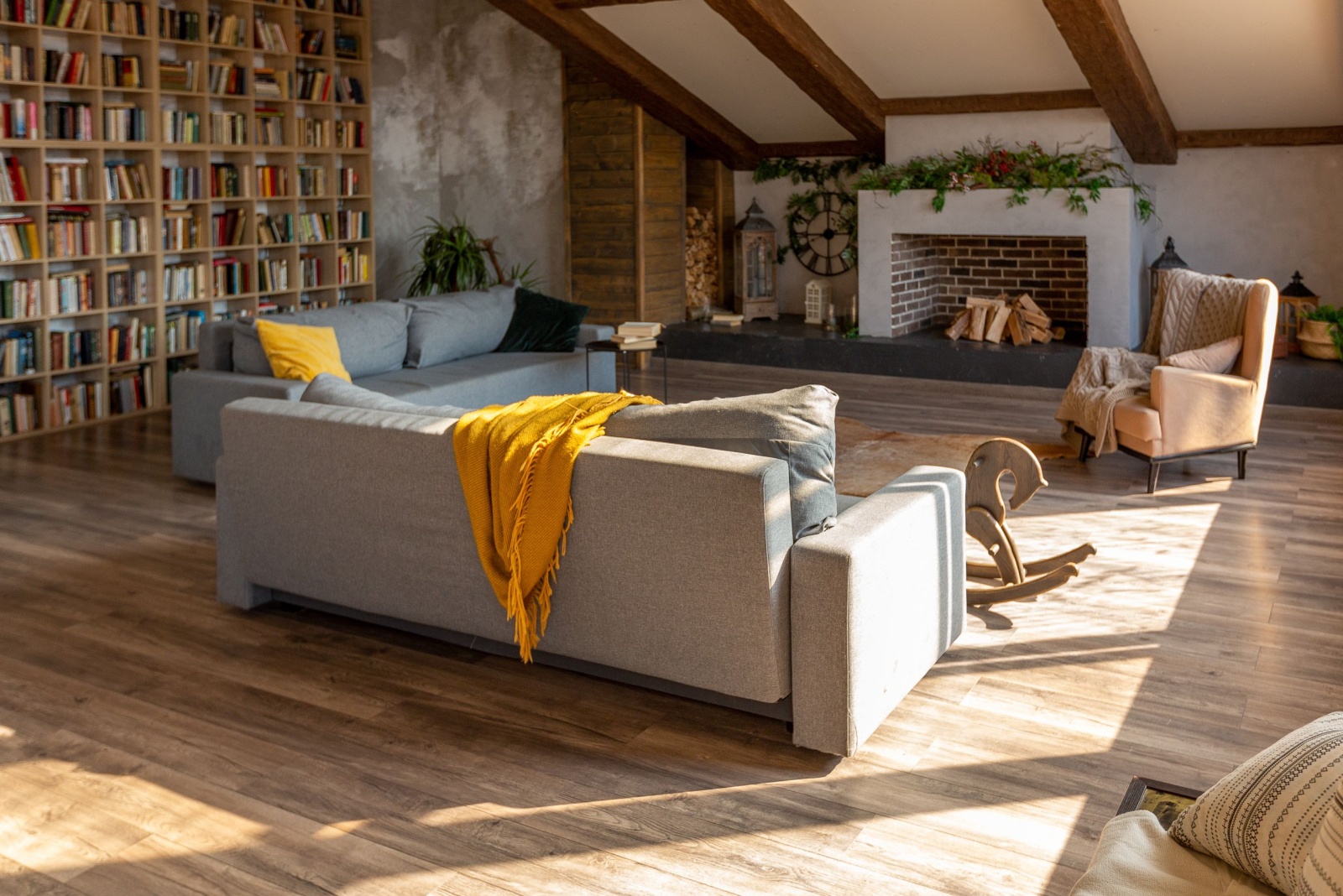 loft living room with a floor to ceiling shelf, gray couch, fireplace