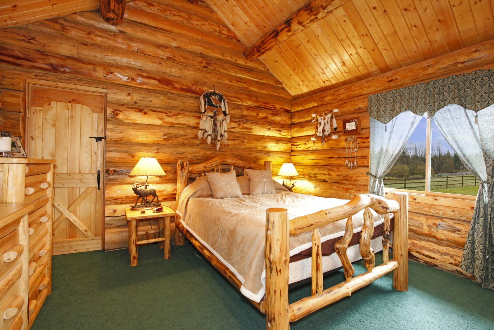 bedroom inspired by a log cabin with a bed made of logs and branches, nightstand in the same style, dresser on the left, and lots of native ornaments in the room