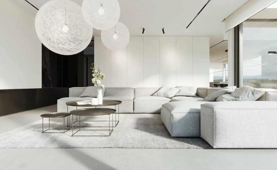 living room with a big white see through chandeliers, light gray couch, black tables in different sizes