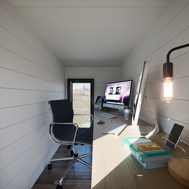 office area with a long, light brown desk and an office chair, glass doors and white walls