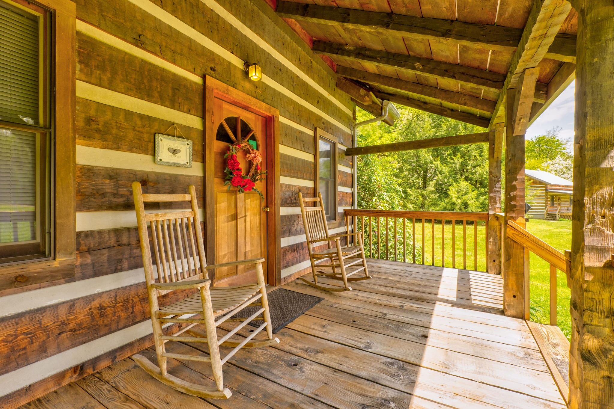 porch of a log cabin with two rocking chairs