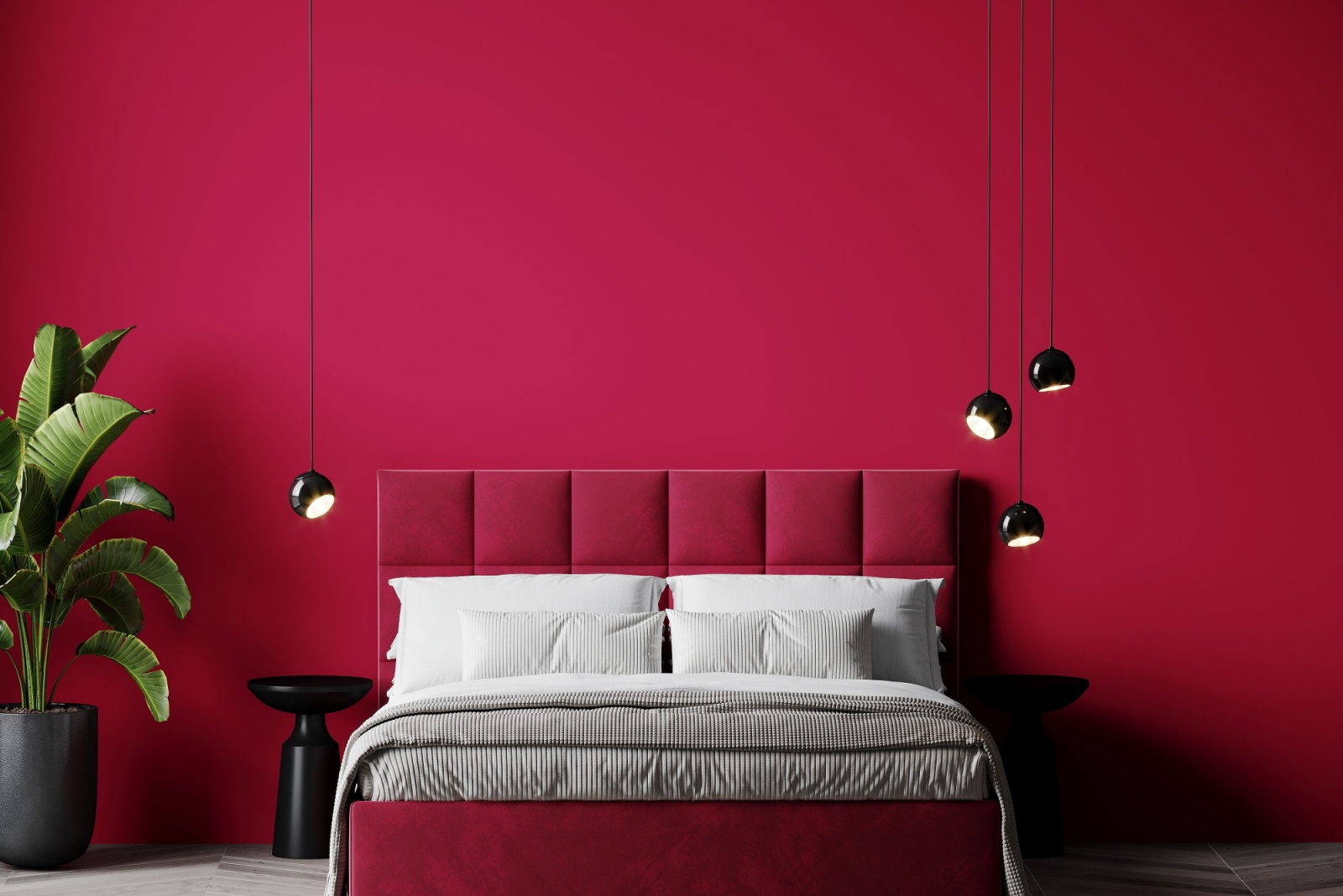 bedroom with a red wall, red velvet bed frame, low hanging round black lamps, black bedside table and a plant