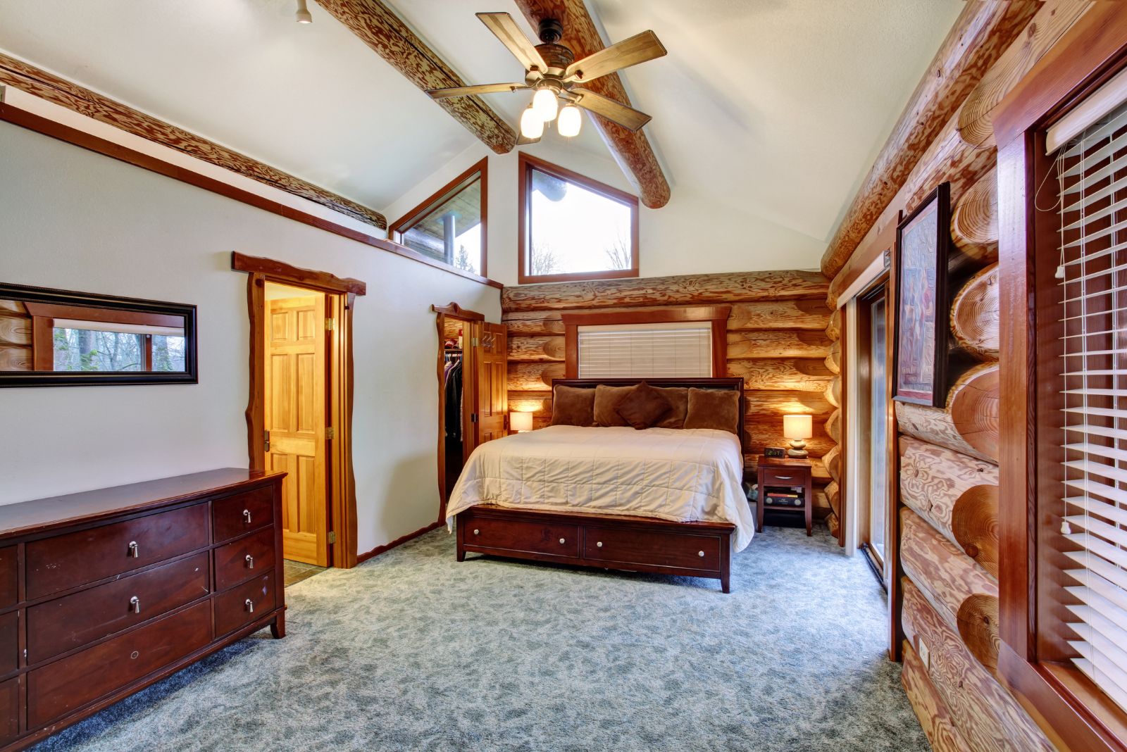 rustic bedroom with lots of exposed wooden beams, furniture in red wood, mosr likely cherry