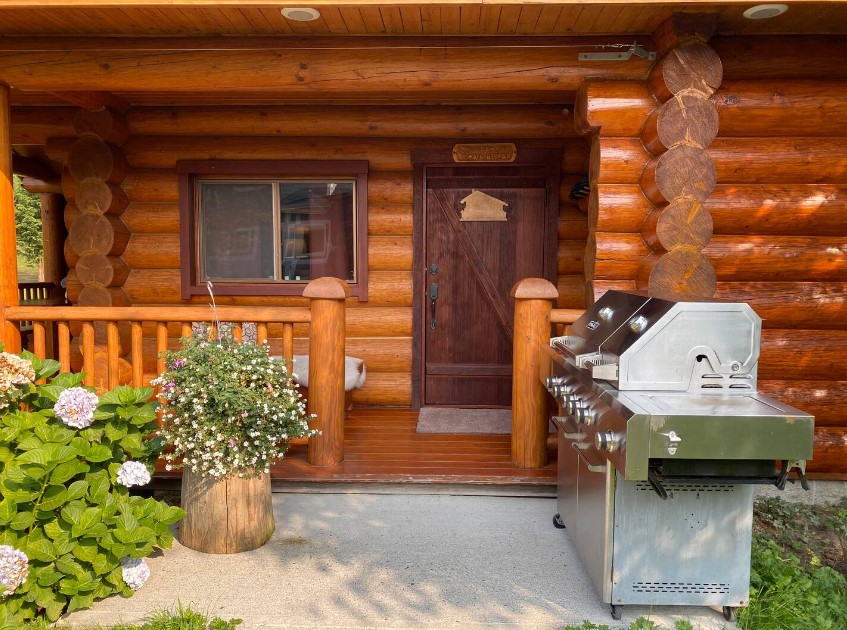 silver grills outside of the cabin on the right and flowers on the left