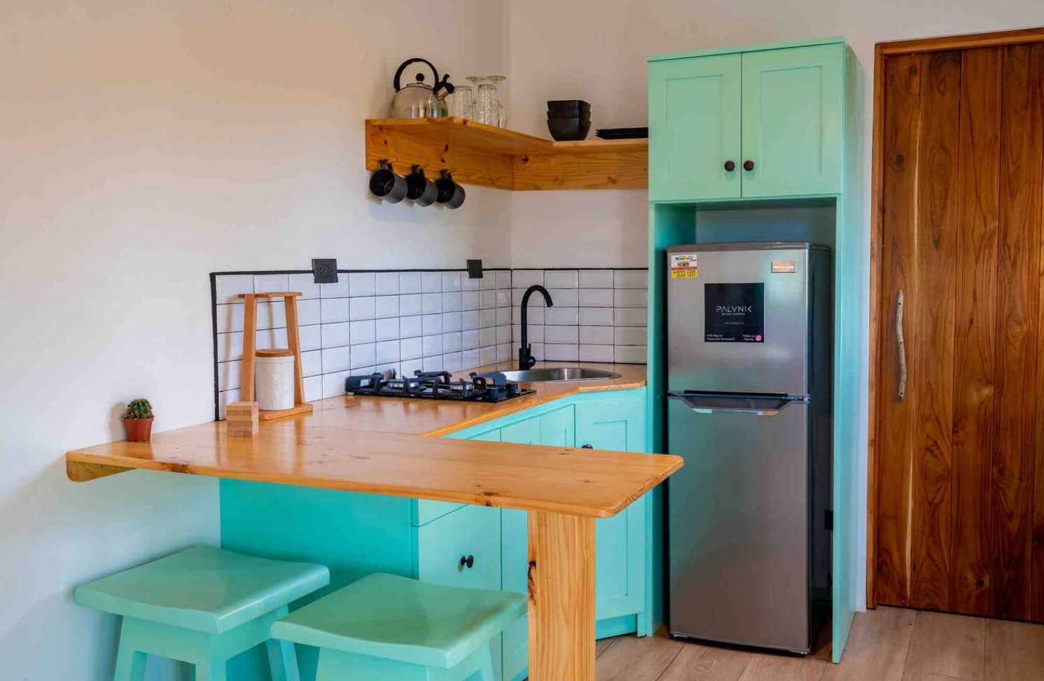 Turquoise kitchen with a wooden breakfast bar