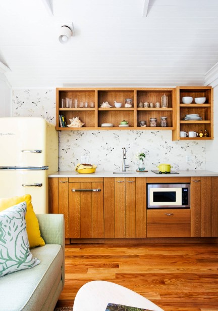 kitchen with wooden cabinets and a patterned wallpaper