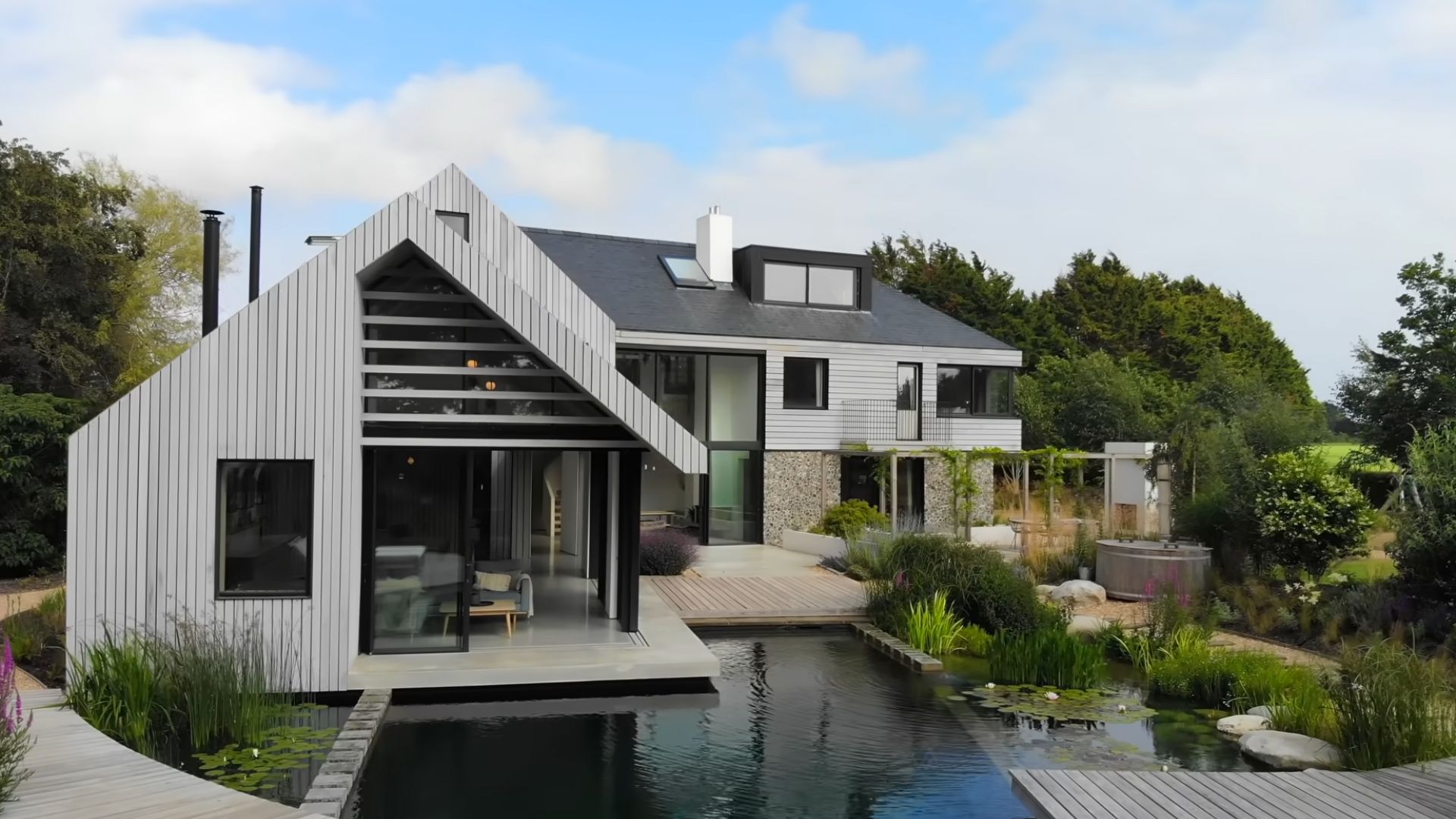 exterior of a modern mansion with a swimming pond