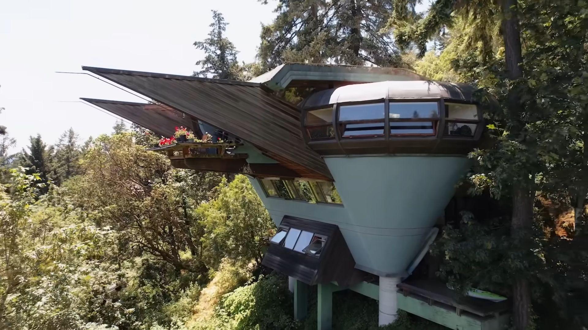 frontal aerial photo of the Elk Rock Residence looking like a funnel house, hidden among the trees