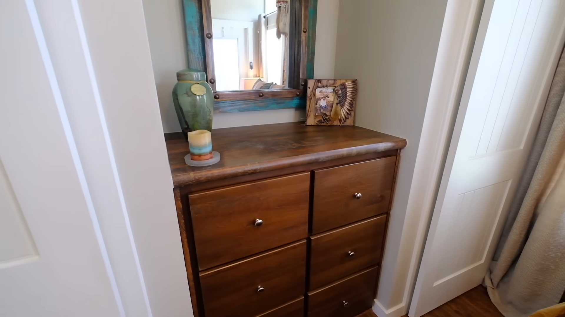 small brown wooden cabinet with a lovely mirror on the wall