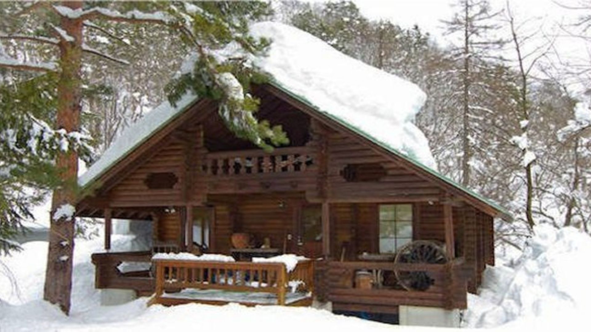 exterior of a cabin covered in snow