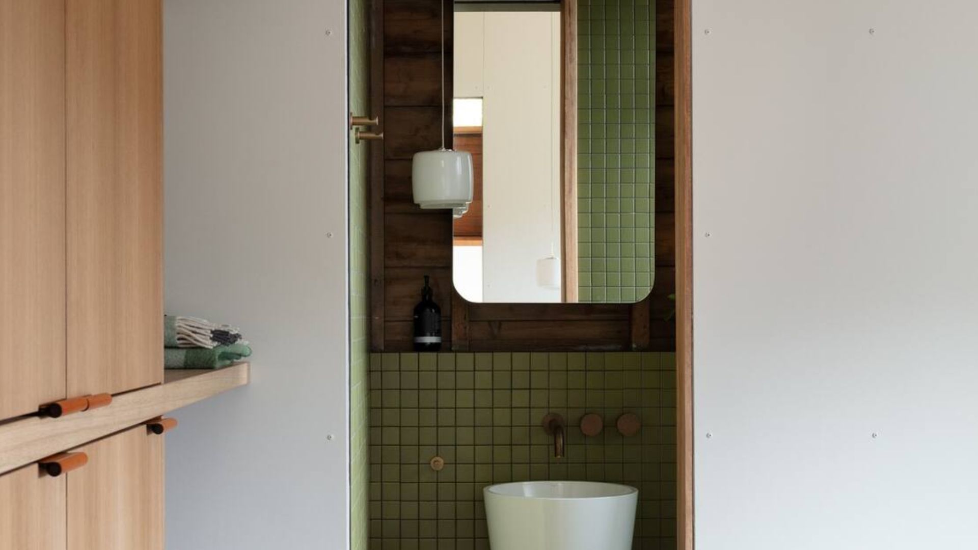 view into the bathroom with green tiles