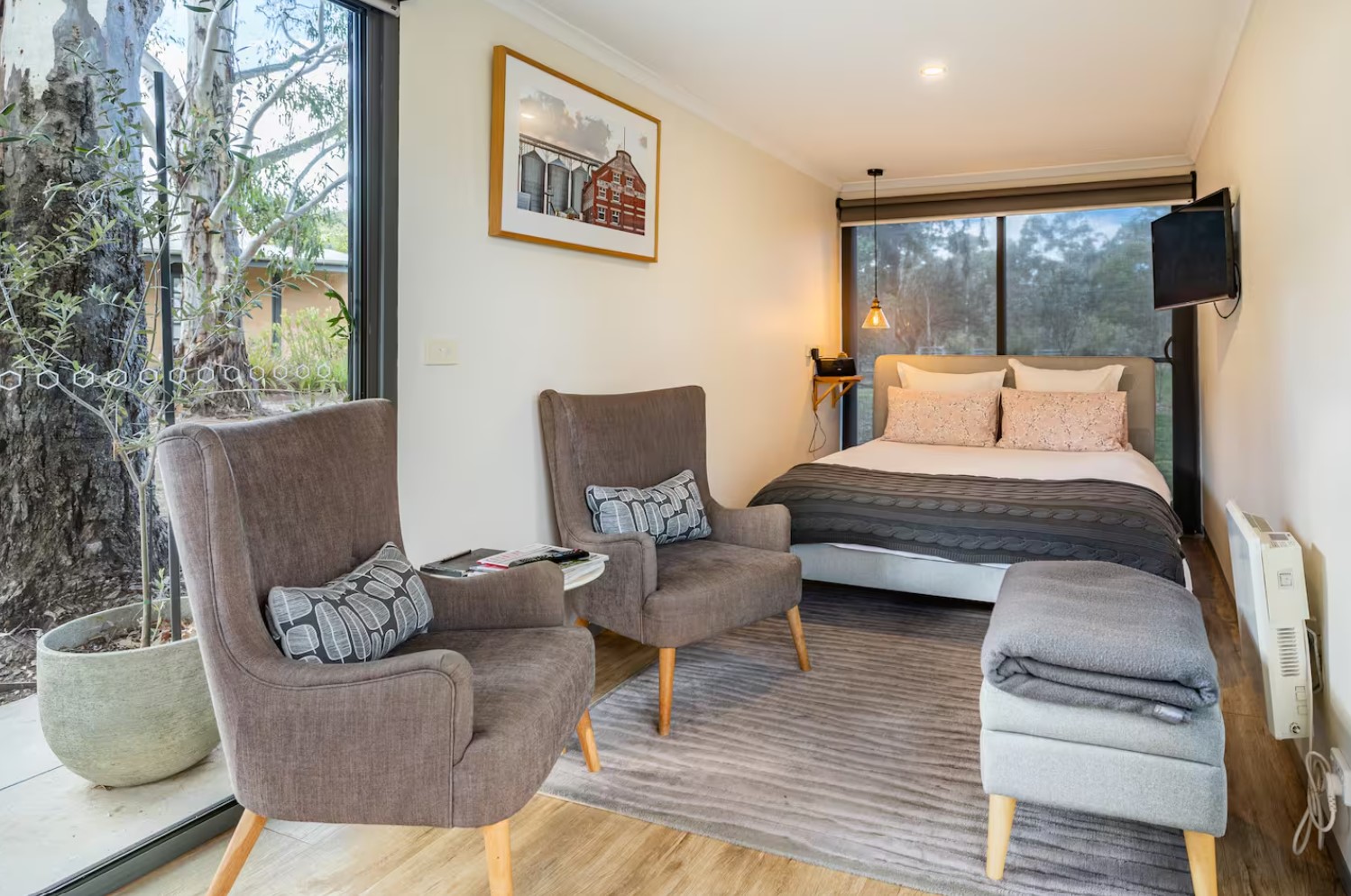 Bedroom and living room combo with a full-sized bed and two armchairs