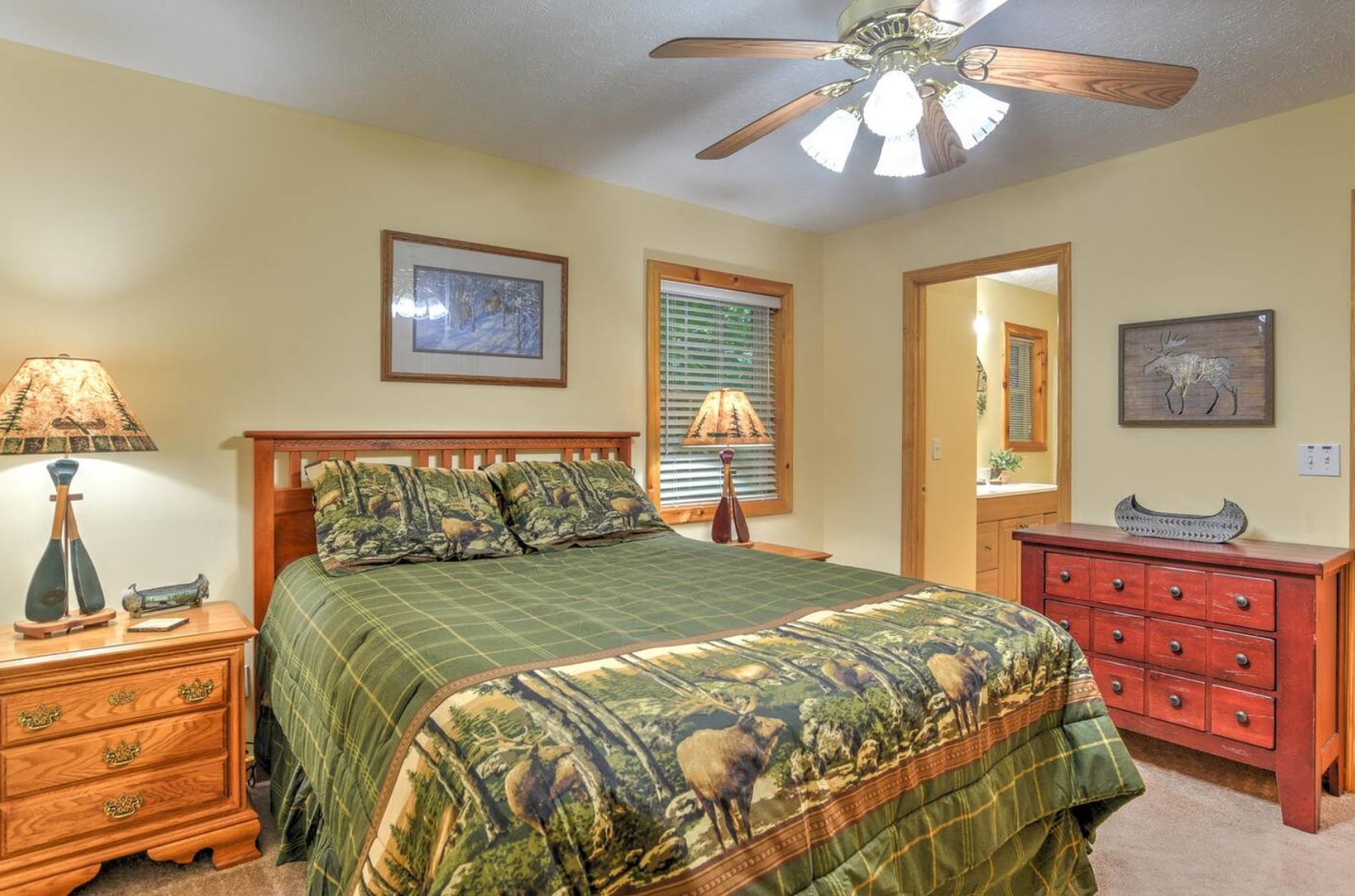 Cabin bedroom with ceiling fan and greens sheets