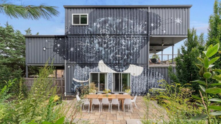exterior of a container house with a big art mural