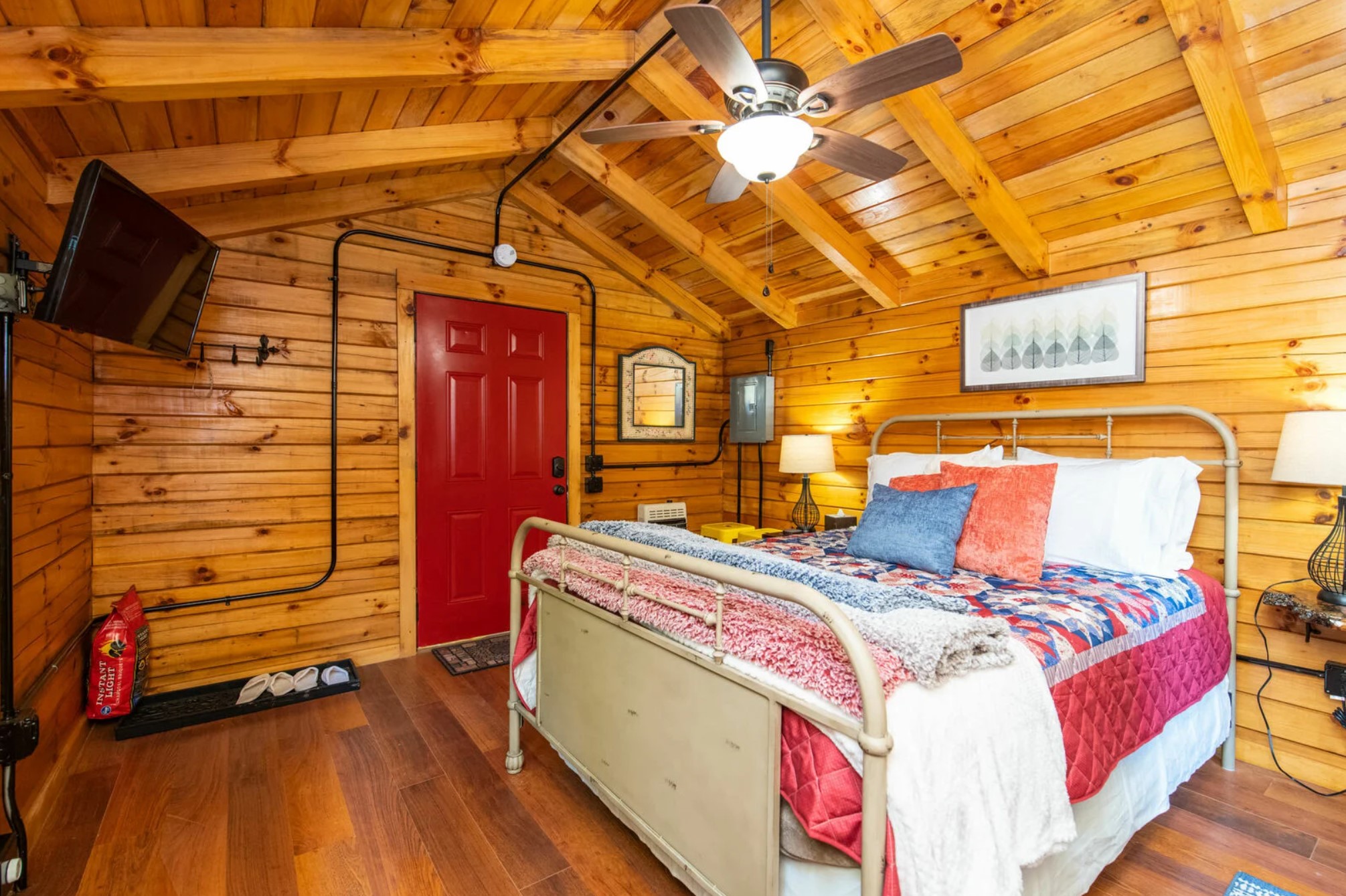 Cozy bedroom in a cabin with a full-sized bed and a ceiling fan