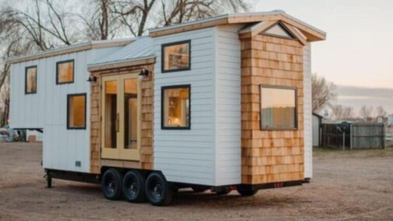 exterior of tiny thow house in white and wood planks with lots of black trim windows