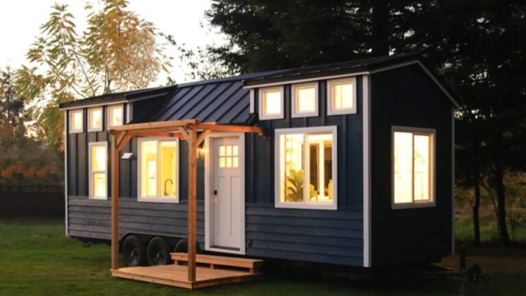 Blue tiny home on wheels with a porch