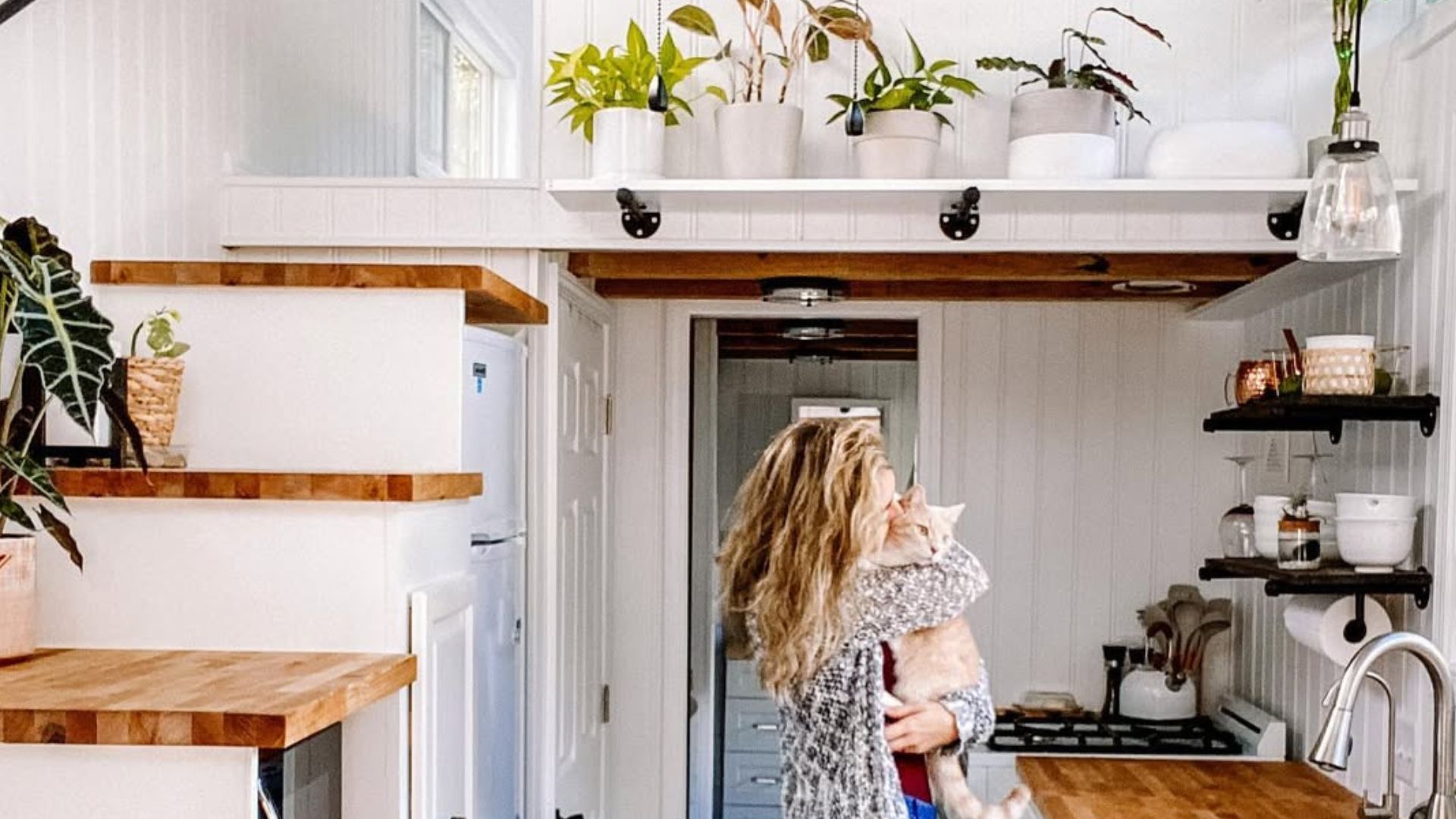 woman hugging her cat in a tiny home