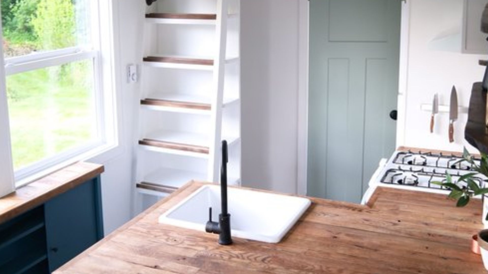 pretty kitchen counter with a farmhosue sink and loft ladders in the back