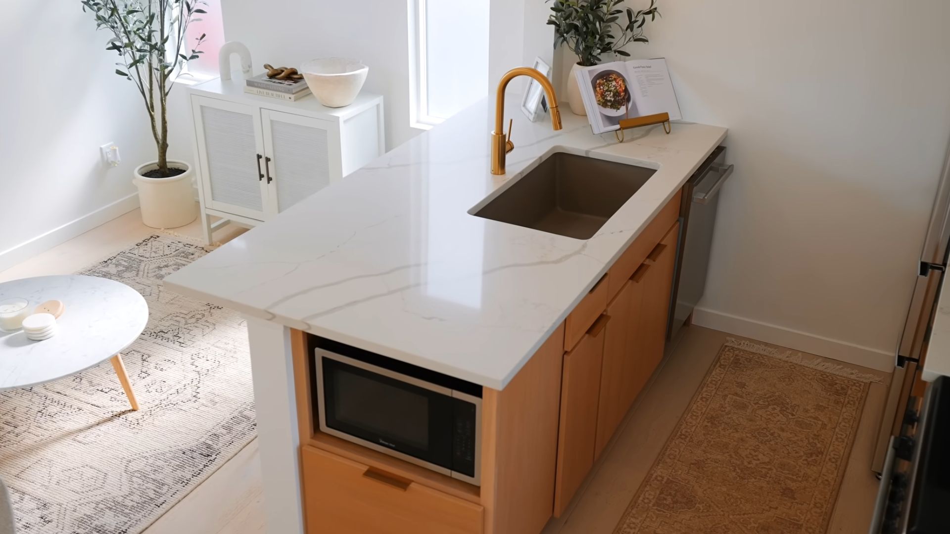 beautiful sleek island with a sink and golden faucet