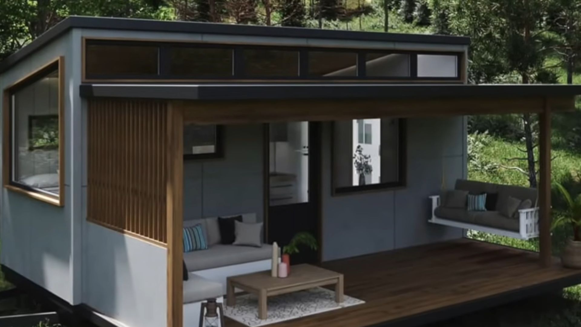 exterior of a tiny house with gray walls, surrounded by greenery