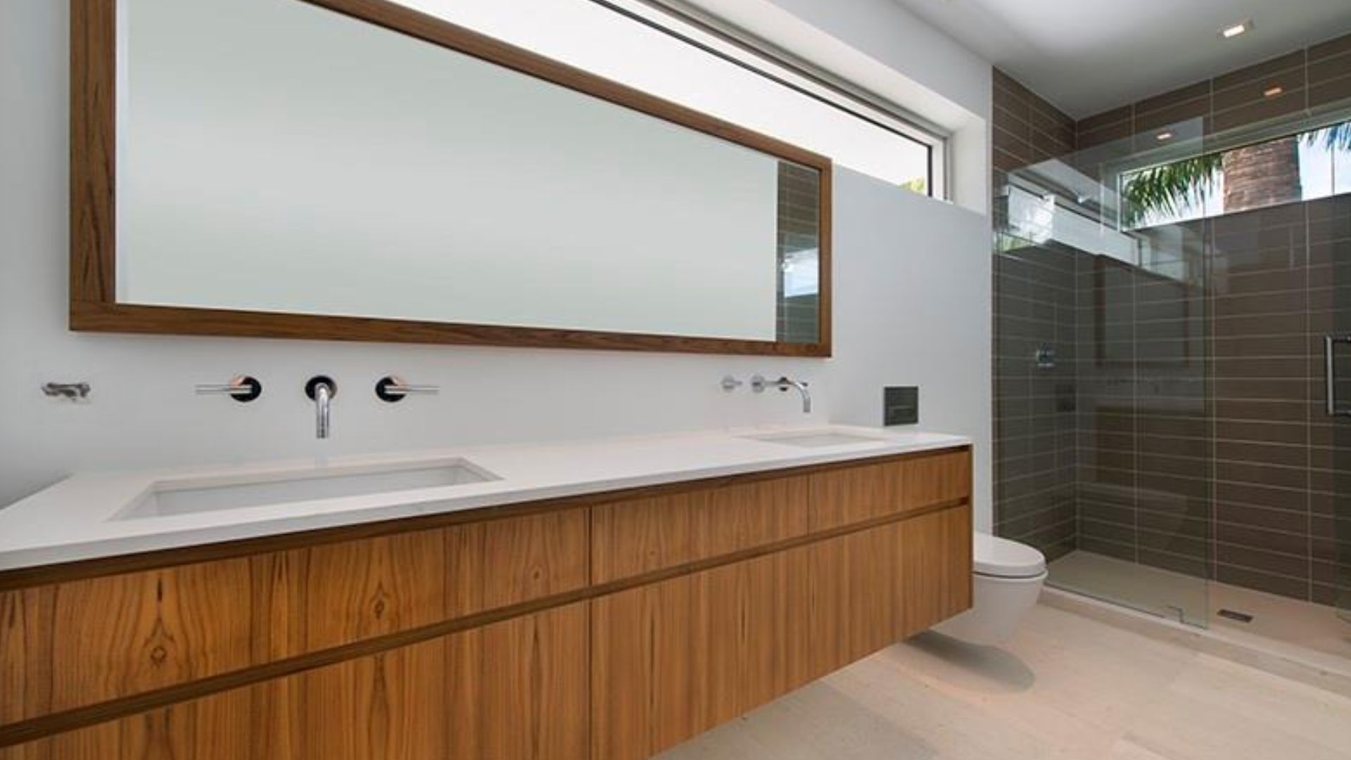 beautiful bathroom with a huge wooden vanity, a large mirror, and a spacious walk-in shower on the right