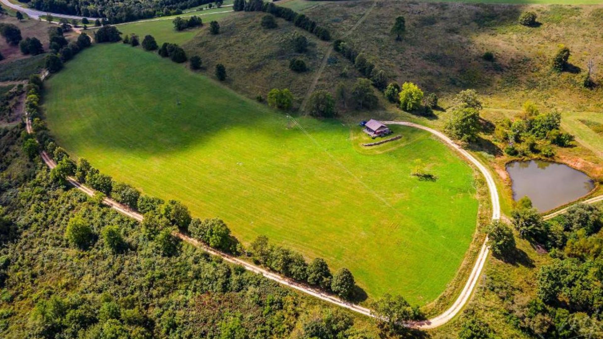 huge green fields around a tiny cabin