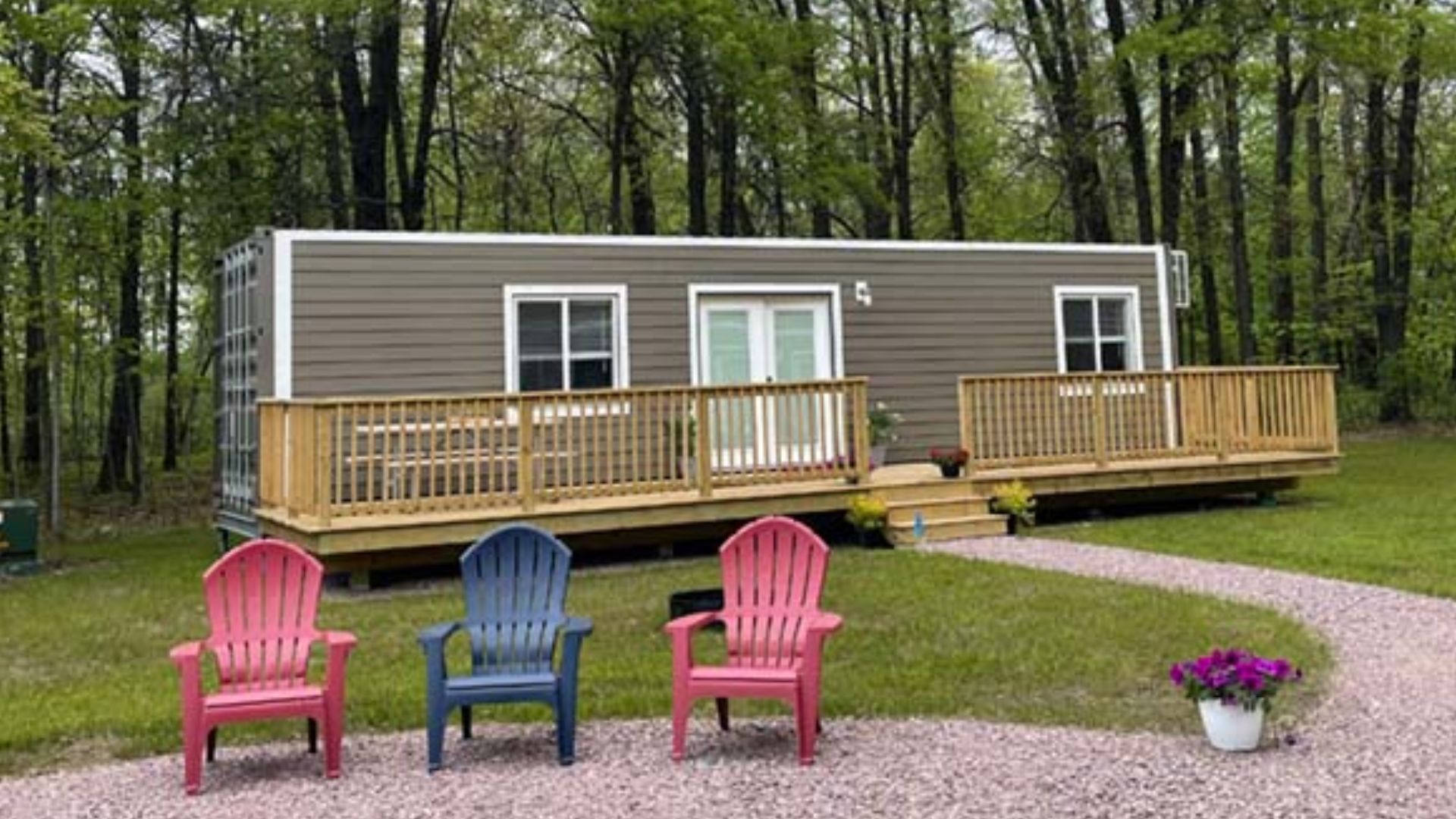 pretty container house with colorful chairs before it