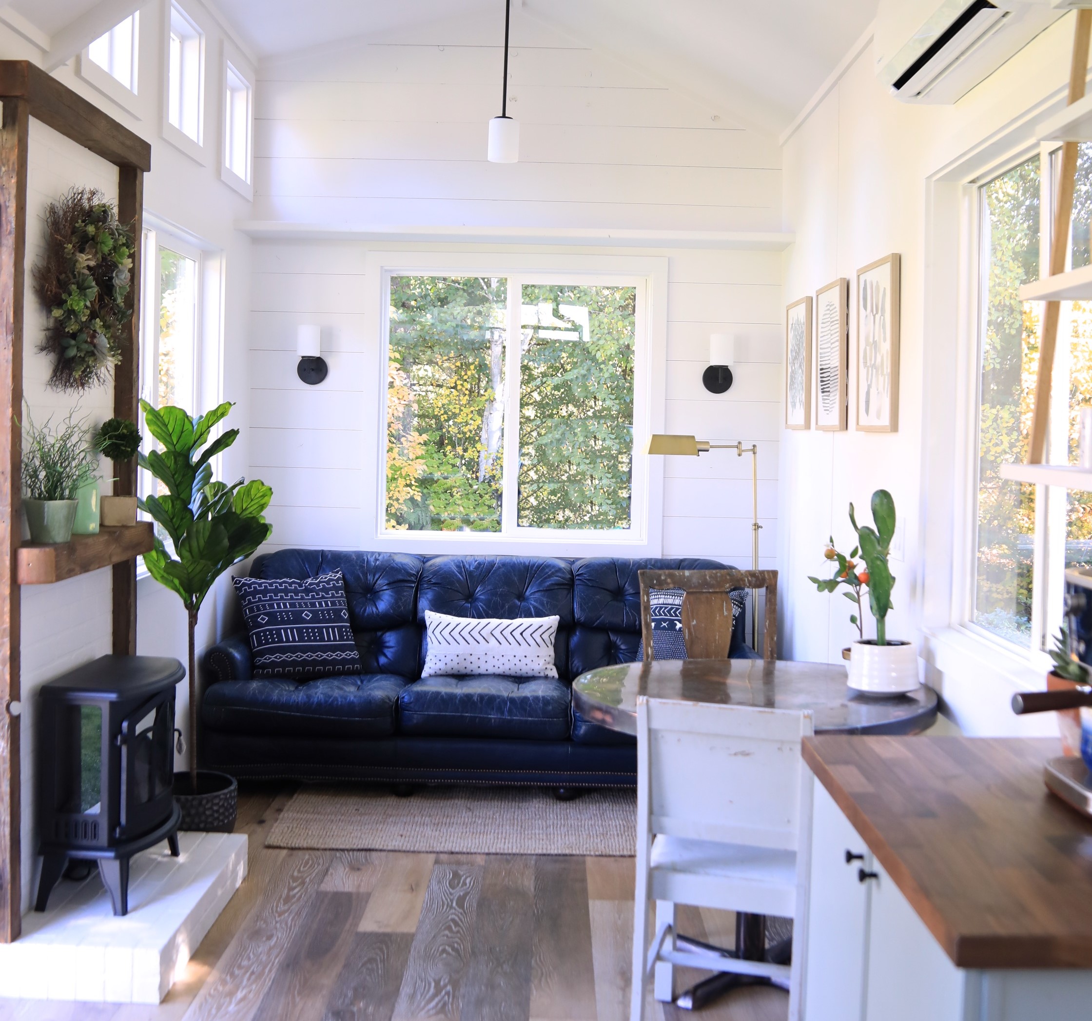 Living room with blue couch and a fireplace in tiny home