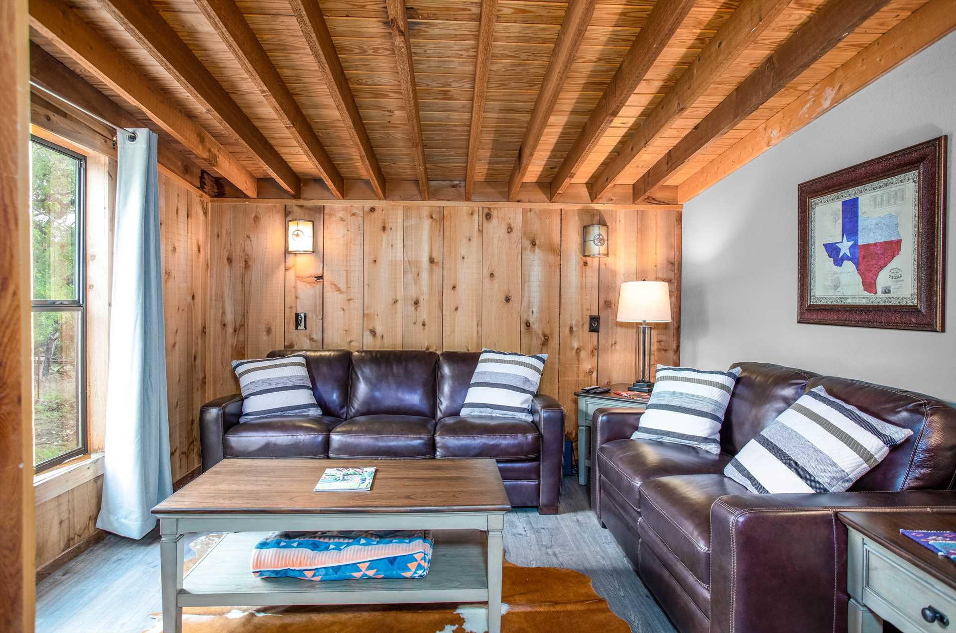 Living room with a leather couch, coffee table and and art