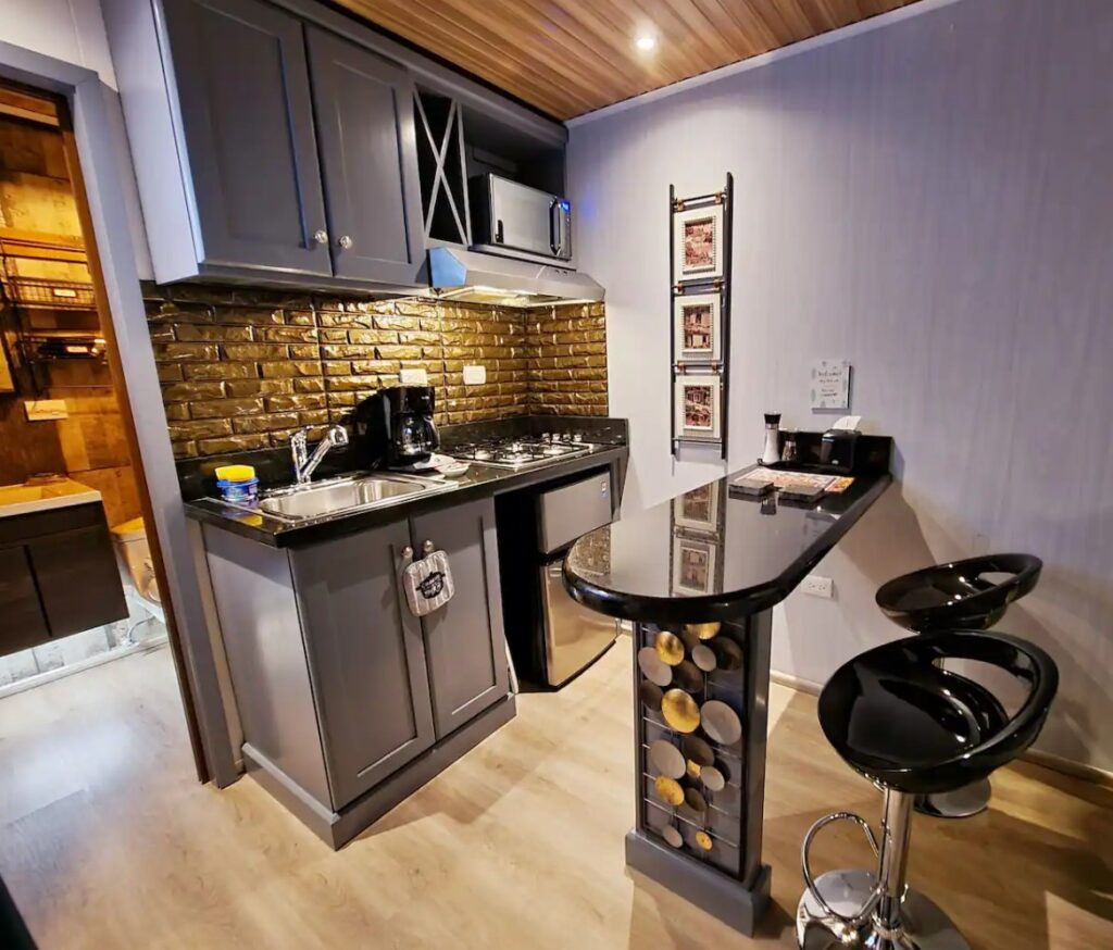 Luxurious tiny kitchen with black countertops and a bar