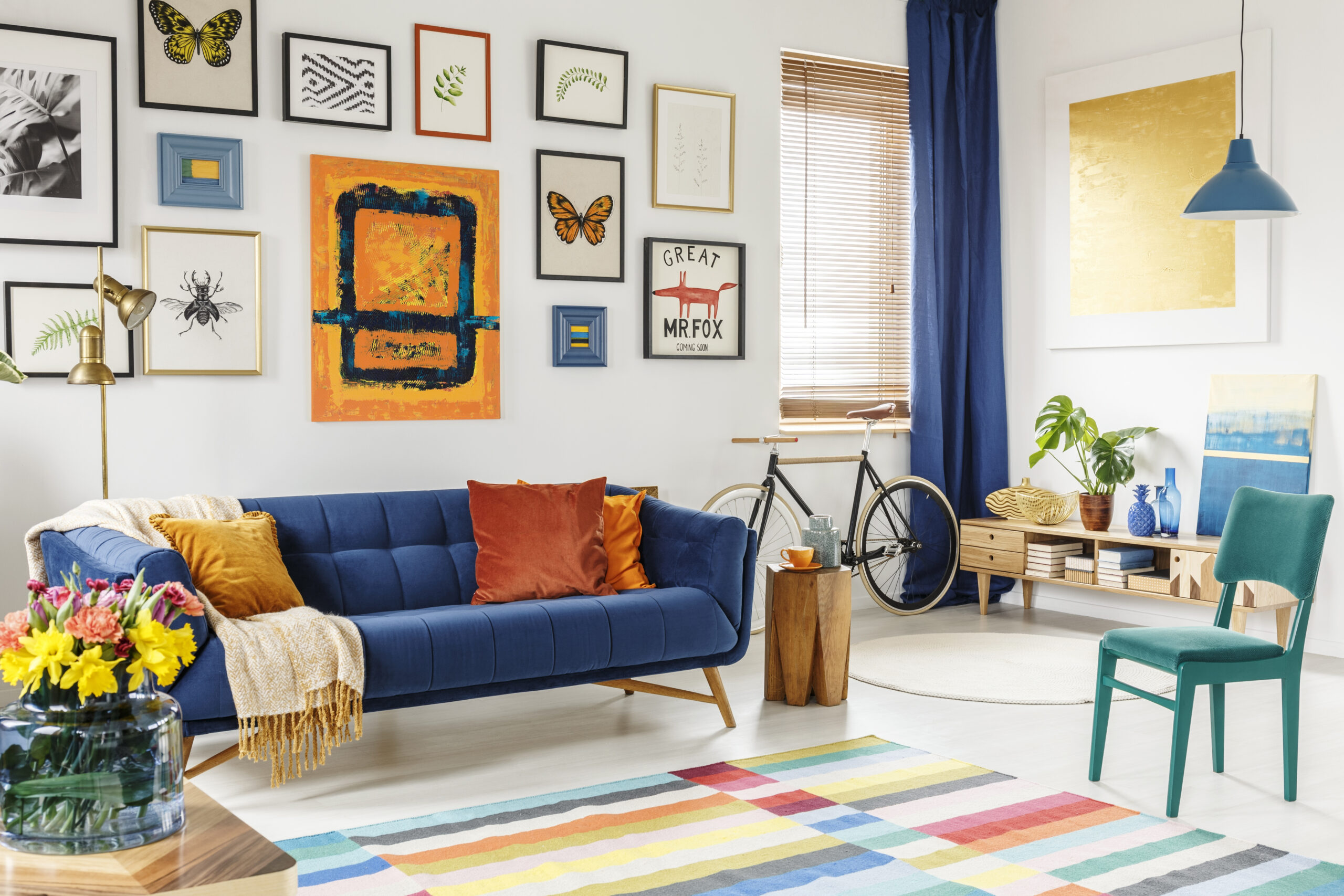 Maximalist living room with a blue couch and art on the wall