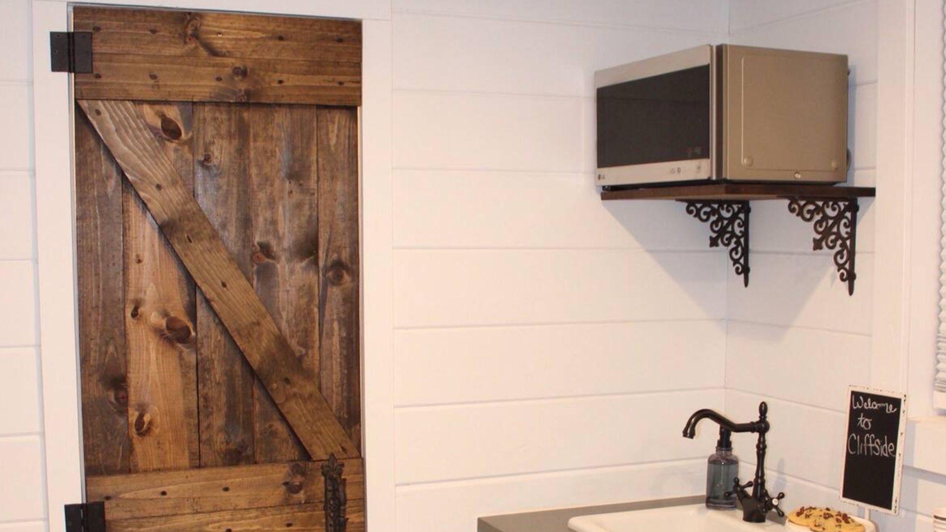 microwave in the kitchen enxt to a barn door