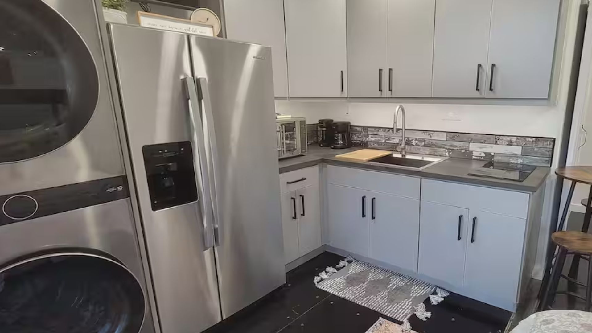 kitchen with white cabinets and a washer and dryer units on the left 