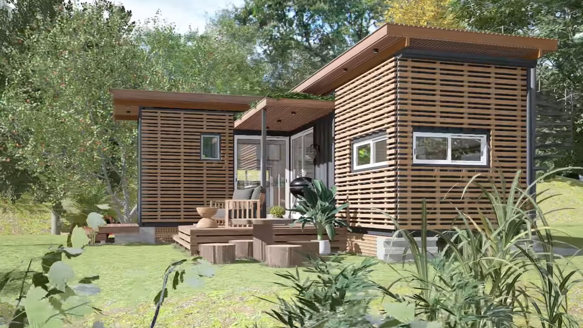 exterior of a container house with two chairs in front, and a wooden table with logs around it