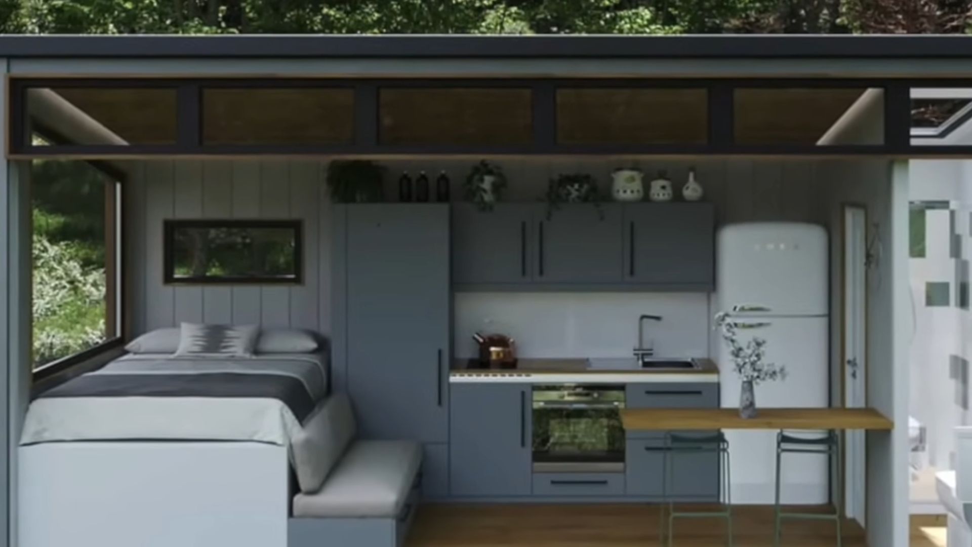 interior of a tiny house with a kitchen and a bed next to it