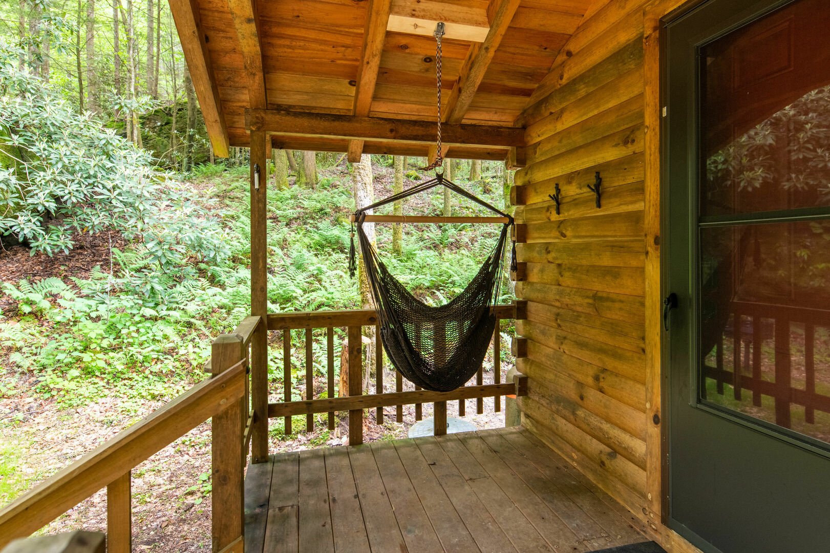 Covered wooden cabin porch with a swing