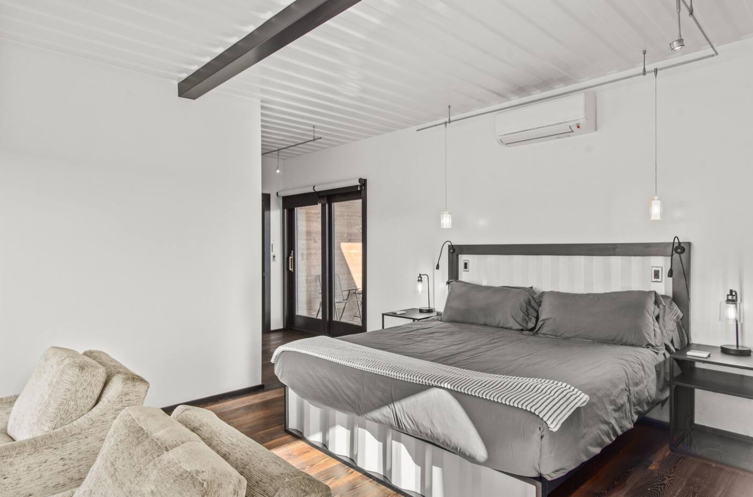 Rustic bedroom with a gray bed and balcony